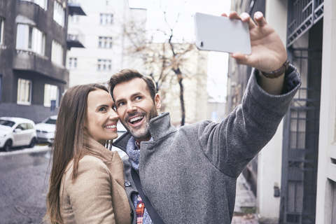 Glückliches Paar macht Selfie in der Stadt, lizenzfreies Stockfoto