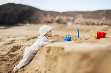 Spain, Lanzarote, baby girl playing on the beach - DIGF03284