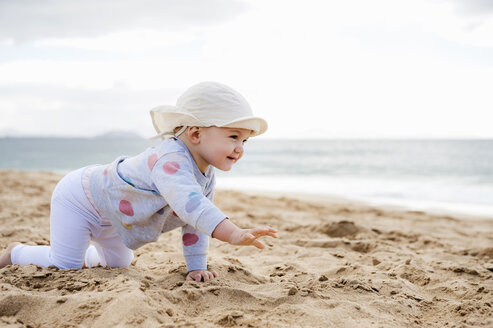 Spanien, Lanzarote, kleines Mädchen krabbelt am Strand - DIGF03288