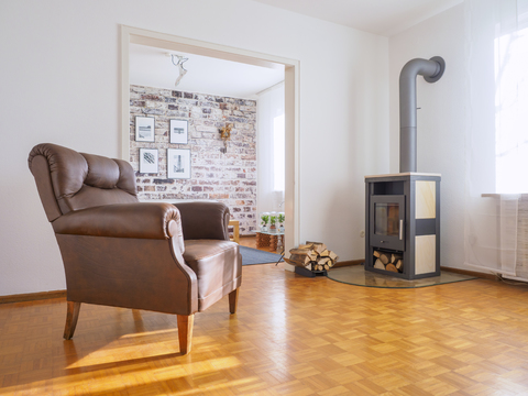 Germany, modern living room, leather chair and fireplace stock photo
