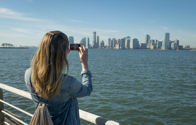 USA, New York, Frau macht Handyfoto von der Skyline von New Jersey - SEEF00003