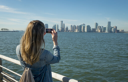 USA, New York, Frau macht Handyfoto von der Skyline von New Jersey - SEEF00003