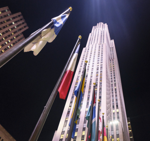 USA, New York City, international flags in front of Rockefeller Center at night stock photo