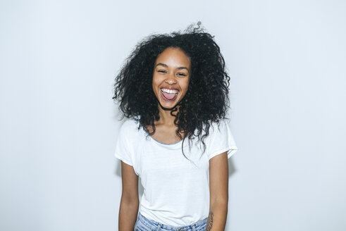 Porträt einer lachenden jungen Frau, die ihre Zunge herausstreckt - KIJF01897