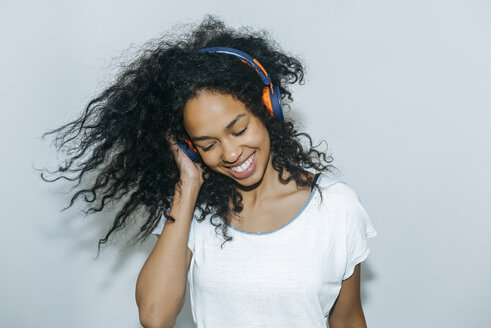 Portrait of happy young woman listening music with headphones - KIJF01902