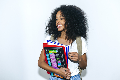 Porträt einer jungen Studentin mit Buch und Mappen, lizenzfreies Stockfoto