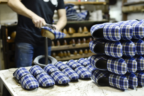 Close-up of shoemaker working on slippers in workshop stock photo