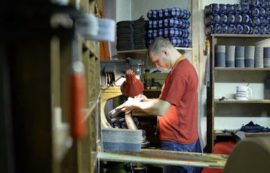 Shoemaker working on slippers in workshop - BFRF01816