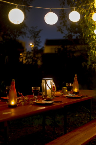 Laid table in garden at night stock photo