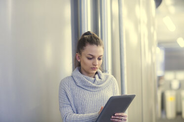 Portrait of serious young woman using tablet in an office - SGF02175