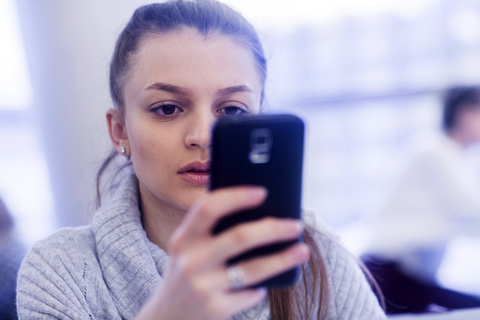 Porträt einer jungen Frau mit Smartphone, lizenzfreies Stockfoto