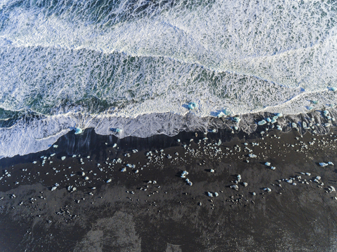 Island, Hof, schwarzer Sandstrand mit Eisstücken, lizenzfreies Stockfoto