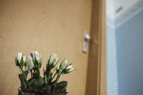 White farewell flowers at apartment door of deceased neighbour stock photo