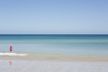 Rückansicht eines im Meer stehenden Mädchens am Strand gegen den klaren Himmel - FSIF00026