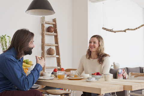 Lächelndes Paar beim Frühstück zu Hause, lizenzfreies Stockfoto