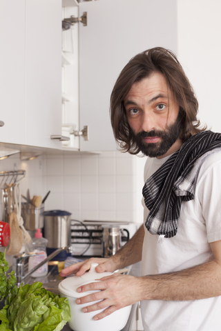 Porträt eines Mannes beim Kochen in der Küche, lizenzfreies Stockfoto