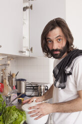 Porträt eines Mannes beim Kochen in der Küche - FSIF00072