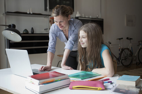 Mutter und Tochter benutzen Laptop am Studiertisch - FSIF00079