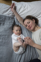 Hohe Winkel Porträt der Mutter mit Baby Mädchen auf Matratze liegend - FSIF00087