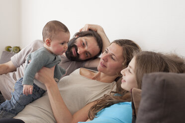 Family looking at baby girl in living room - FSIF00095