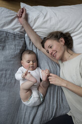 Directly above shot of smiling mother looking at baby girl at home - FSIF00097