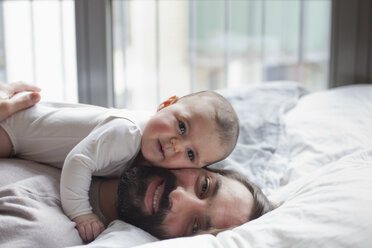 Porträt eines liebenden Vaters mit einem im Bett liegenden kleinen Mädchen - FSIF00102