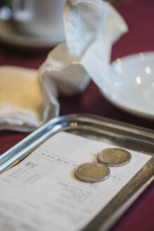 Rechnung und Trinkgeld in einem Teller auf dem Restauranttisch - FSIF00131