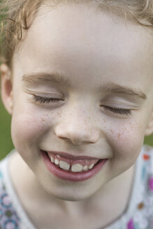 Close-up of cute girl smiling with eyes closed - FSIF00164