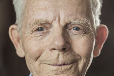 Close-up portrait of smiling senior man over colored background - FSIF00166