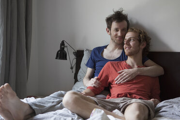 Loving gay couple relaxing in bed at home - FSIF00189