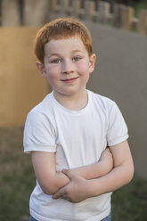 Porträt eines kleinen Jungen mit verschränkten Armen im Hof - FSIF00235