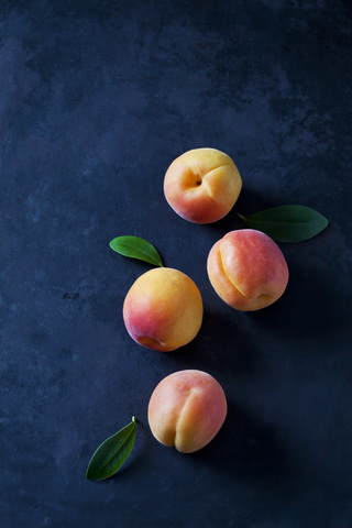 Four apricots on dark ground stock photo
