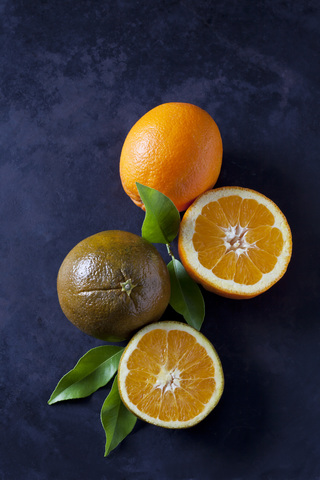 Sliced and whole chocolate oranges on dark ground stock photo