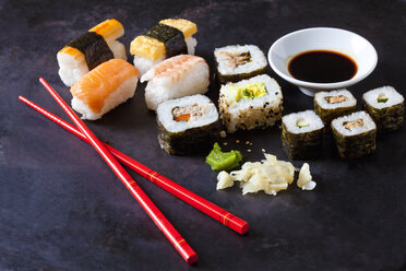 Sushi-Variationen mit Wasabi, Ingwer und einer Schale Sojasauce auf dunklem Grund - CSF28917