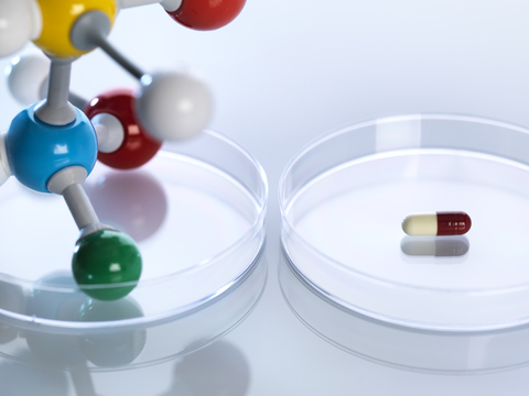 Molecular model next to a capsule in petri dishes stock photo