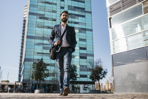 Businessman walking outside office building stock photo