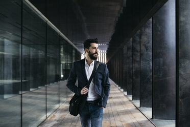 Businessman walking along arcade - JRFF01553