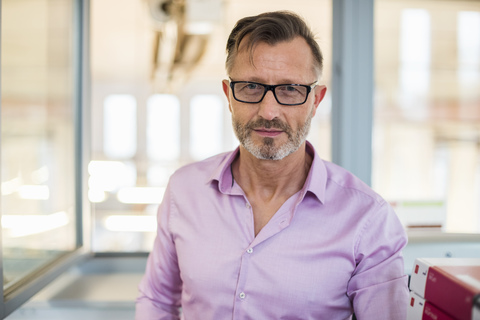 Porträt eines selbstbewussten reifen Geschäftsmannes im Büro, lizenzfreies Stockfoto