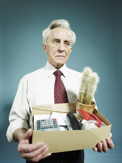 Ein älterer Mann trägt eine Kiste mit Habseligkeiten, nachdem er entlassen wurde - FSIF00394