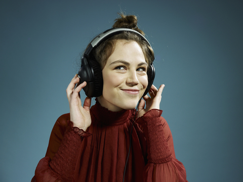 Eine junge hippe Frau mit Kopfhörern und einem Lächeln, lizenzfreies Stockfoto