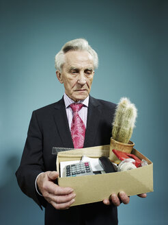 Ein älterer Mann trägt eine Kiste mit Habseligkeiten, nachdem er entlassen wurde - FSIF00406