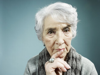 Eine ältere Frau, die mit dem Zeigefinger an die Lippen denkt - FSIF00409