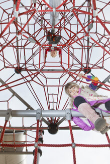 Two kids looking down from jungle gym - FSIF00416