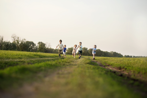 Kinder laufen auf einem Feld, lizenzfreies Stockfoto