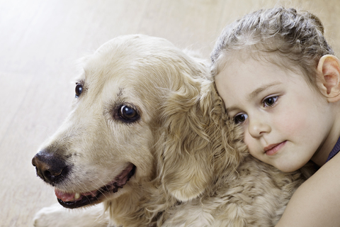 Close-up of a young girl hugging a dog stock photo