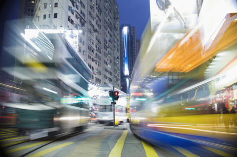 Buses moving through a city at night, blurred motion stock photo