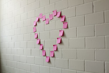 Blank adhesive notes arranged into the shape of a heart on a brick wall - FSIF00464