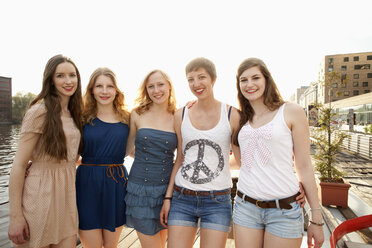 Fünf fröhliche junge Freundinnen in einer Reihe stehend, Spree, Berlin, Deutschland - FSIF00483