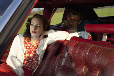 Eine Rockabilly-Frau und ein Rockabilly-Mann sitzen in einem Oldtimer - FSIF00490