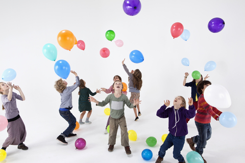 Eine Gruppe von Kindern spielt mit Luftballons, lizenzfreies Stockfoto